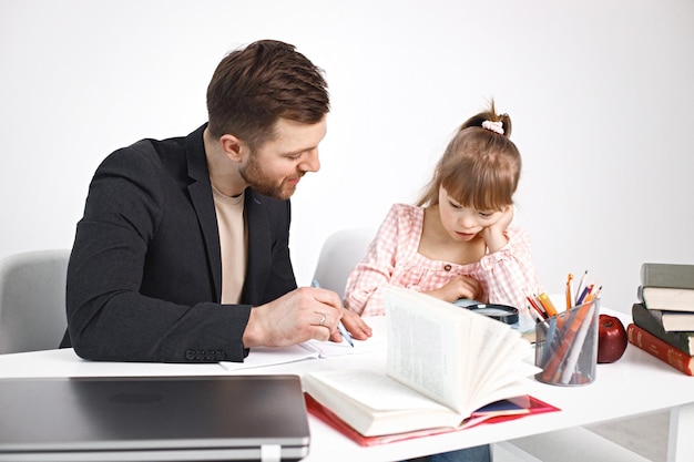 Menina com síndrome de Down estudando com seu professor em casa