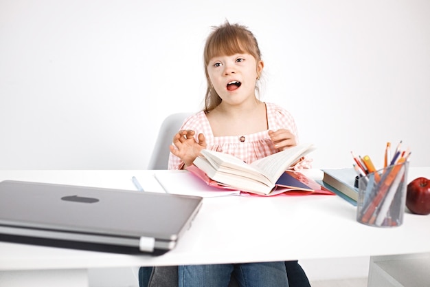 Foto grátis menina com síndrome de down estudando enquanto está sentado na mesa em casa