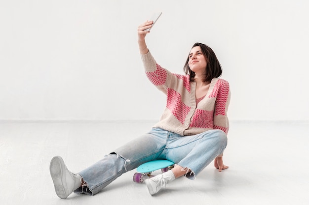 Menina com skate tomando selfie