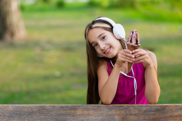 Menina com sorvete de chocolate e fones de ouvido