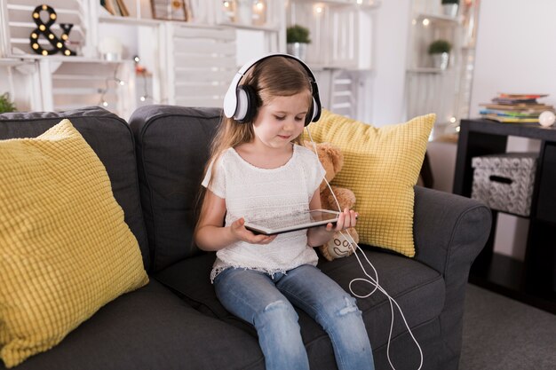 Menina com tablet e fones de ouvido