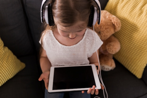 Menina com tablet em casa