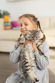 Menina com um gatinho fofo nos braços