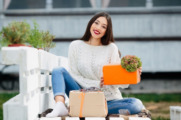 Menina com um presente de laranja