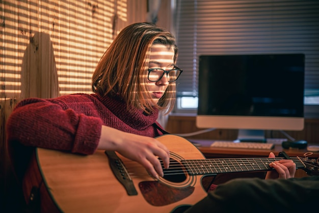 Menina com um violão sob o sol através das cortinas