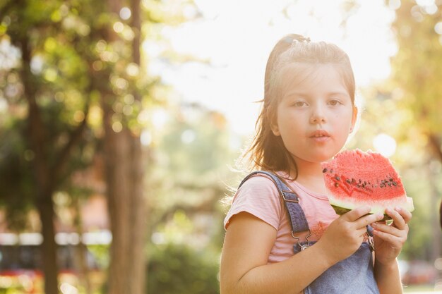 Menina com uma fatia de melancia