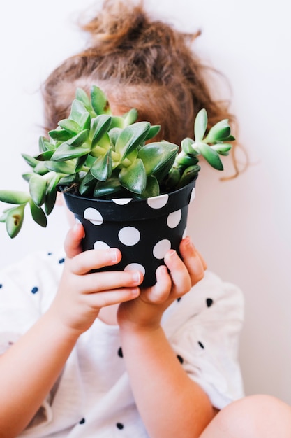 Menina com vaso de plantas