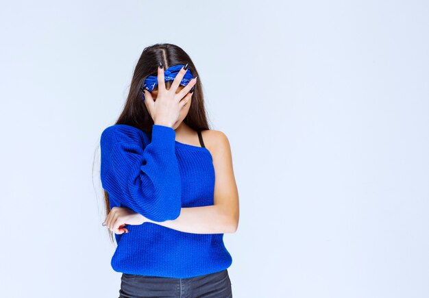 Foto grátis menina com vestido de festa azul, segurando a cabeça enquanto ela está confusa e surpresa.