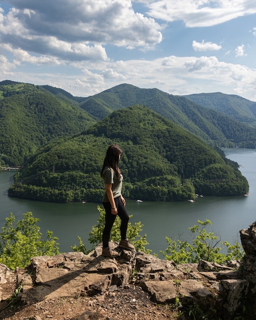 Menina com vista para a paisagem do lago de montanha em Tarnita, Transilvânia, Romênia