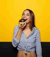 Foto grátis menina comendo rosquinha com cobertura de chocolate