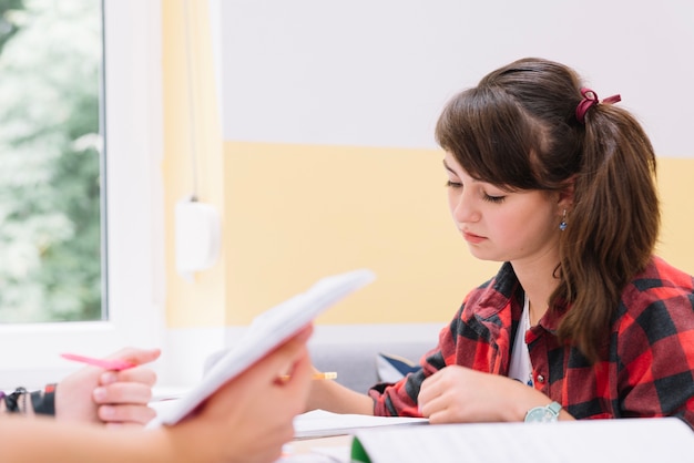 Menina concentrada na mesa estudando