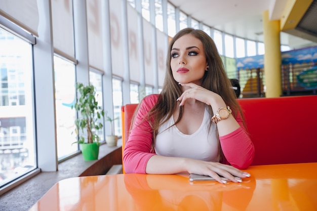 Menina concentrada sentado em um restaurante