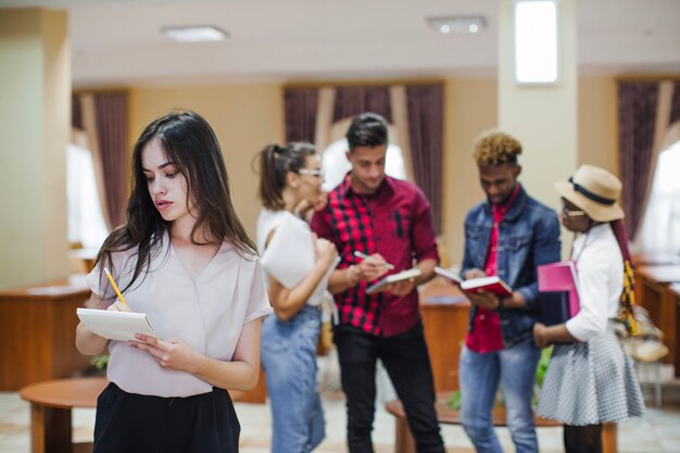 Menina concentrada tomando notas na sala de aula