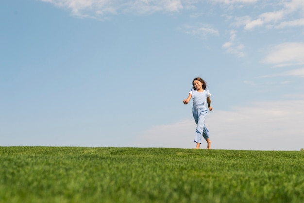 Menina correndo descalço na grama