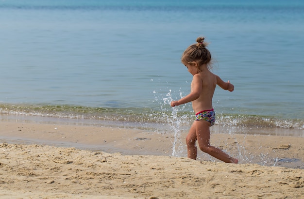 Menina correndo na praia, emoções alegres