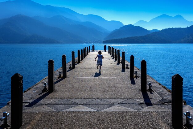 Menina correndo no caminho no lago Sun moon, Taiwan.