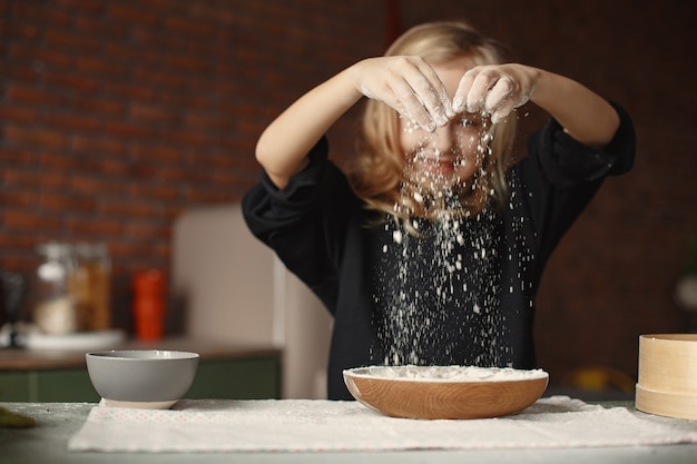 Menina cozinhar a massa para biscoitos