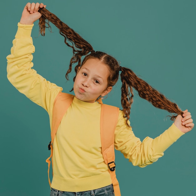 Menina da escola com camisa amarela brincando