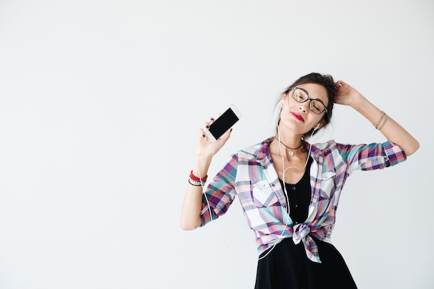 Menina dançando e mostrando o telefone