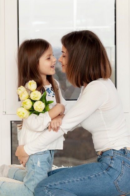 Menina dando flores para mãe