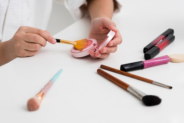 Menina de alto ângulo, brincando com seus cosméticos de mães