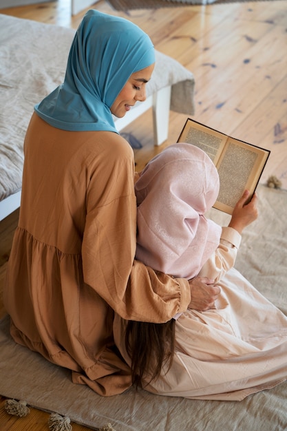 Menina de alto ângulo e mãe lendo juntos