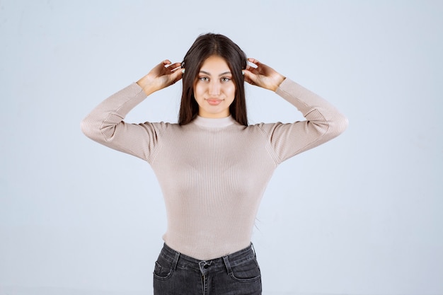 Menina de camisa cinza dando poses positivas e atraentes.