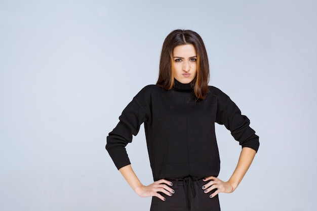 Foto grátis menina de camisa preta dando poses atraentes e neutras. foto de alta qualidade