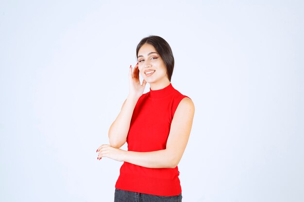 Menina de camisa vermelha dando poses neutras, positivas e atraentes.