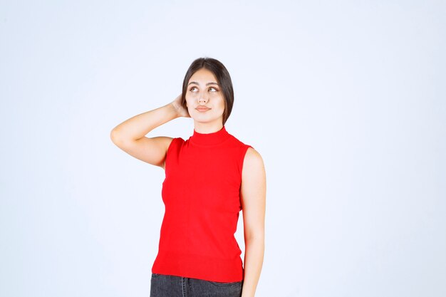 Menina de camisa vermelha dando poses neutras, positivas e atraentes.