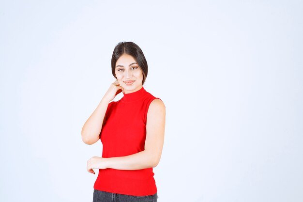 Menina de camisa vermelha dando poses neutras, positivas e atraentes.