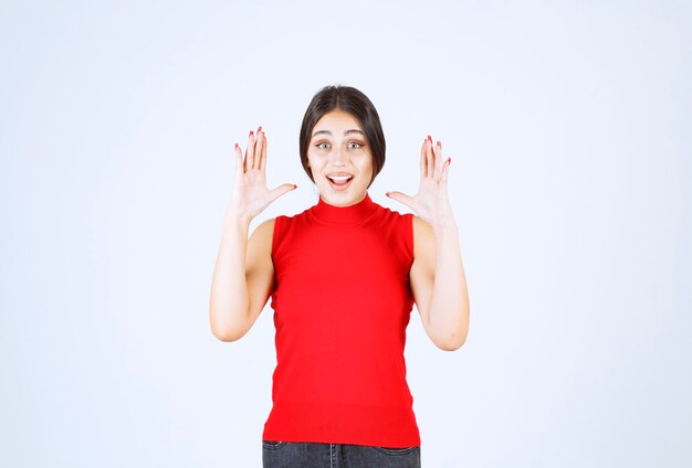 Menina de camisa vermelha, evitando algo.