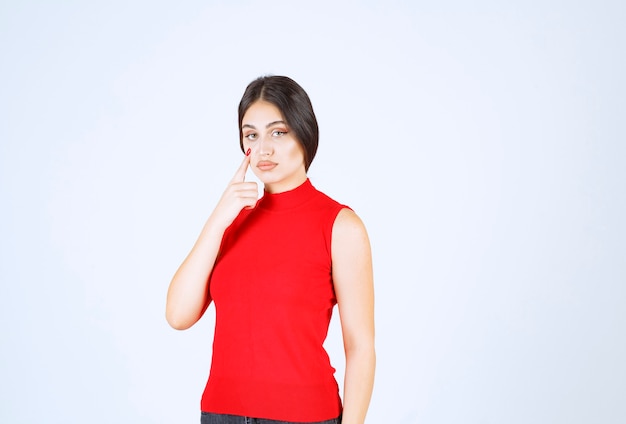 Menina de camisa vermelha parece insatisfeita.