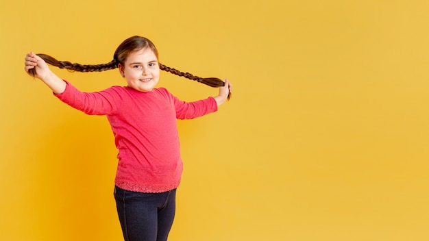 Foto grátis menina de cópia-espaço brincando com o cabelo dela