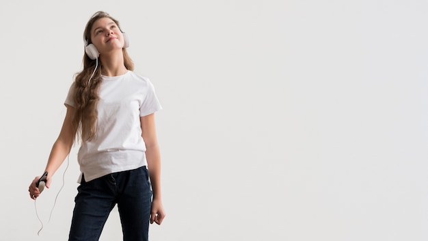 Menina de cópia-espaço com fones de ouvido