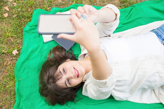 Foto grátis menina de faculdade relaxada alegre que dispara-se