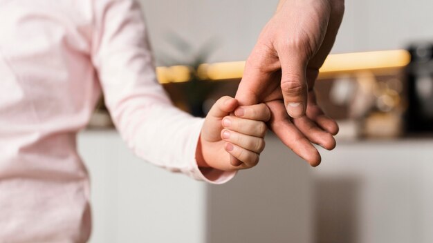 Menina de mãos dadas com o pai