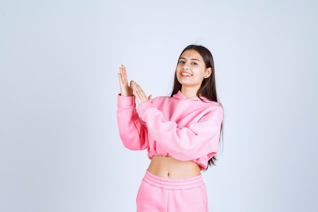 Menina de pijama rosa fazendo poses positivas e desagradáveis