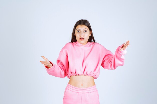 Foto grátis menina de pijama rosa parece confusa e duvidosa