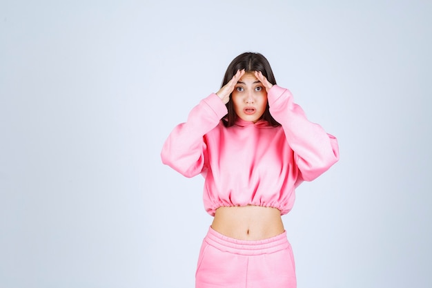 Foto grátis menina de pijama rosa parece confusa e duvidosa