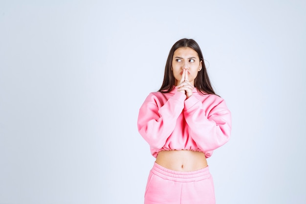 Foto grátis menina de pijama rosa parece confusa e inexperiente