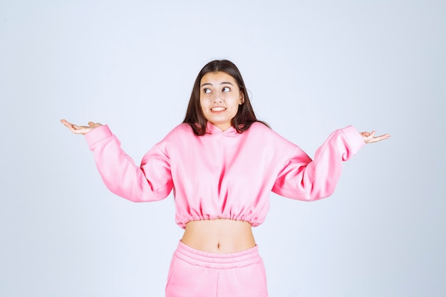 Foto grátis menina de pijama rosa parece confusa e inexperiente