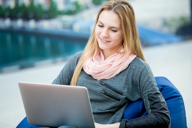 Menina de sorriso com um computador portátil