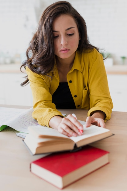 Foto grátis menina de tiro completo estudando dentro de casa