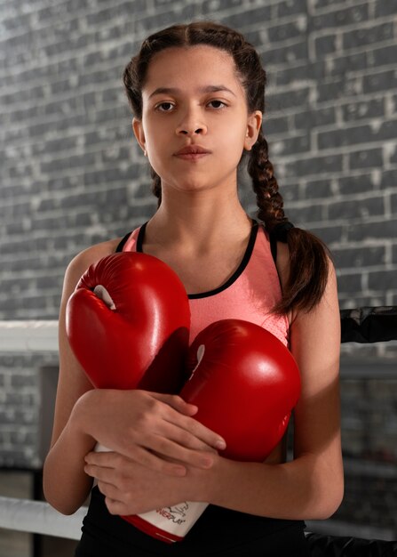 Menina de tiro médio aprendendo boxe