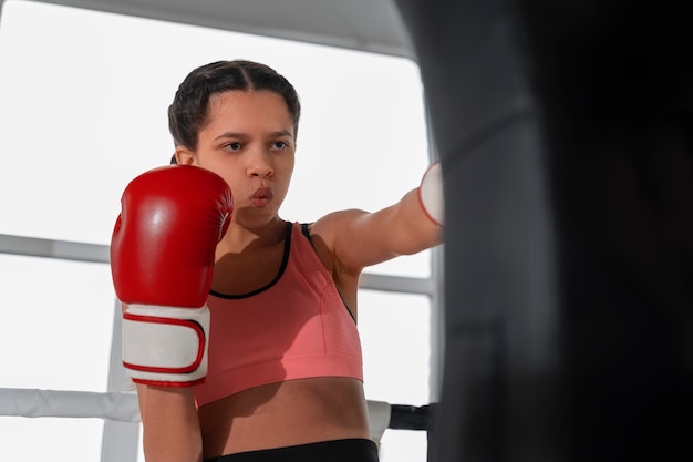 Foto grátis menina de tiro médio aprendendo boxe