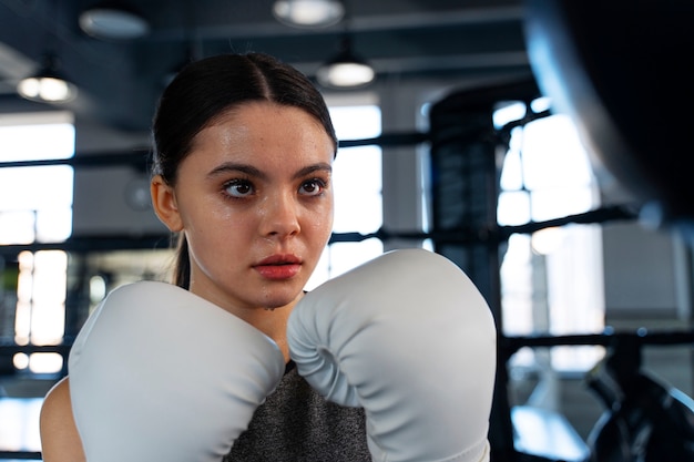 Foto grátis menina de tiro médio aprendendo boxe