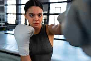 Foto grátis menina de tiro médio aprendendo boxe