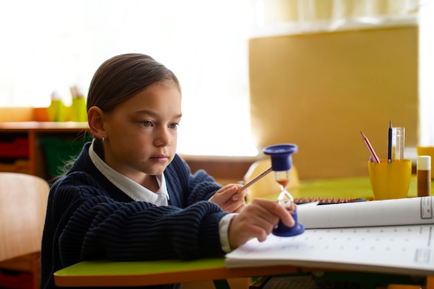 Foto grátis menina de tiro médio aprendendo matemática na escola