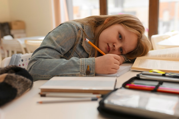 Menina de tiro médio aprendendo na escola